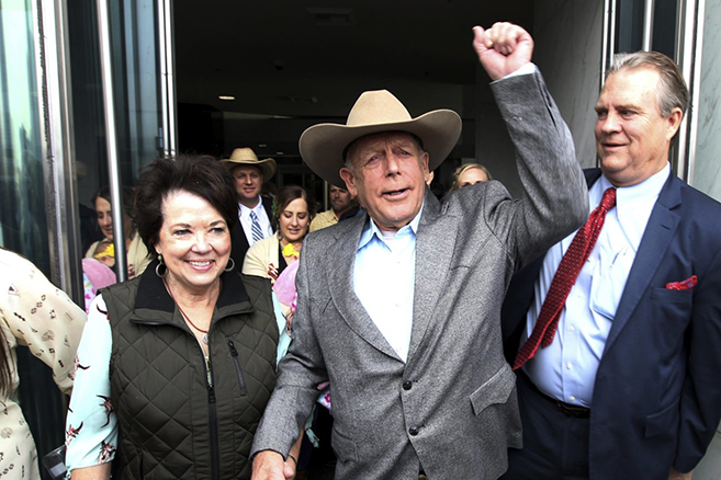 Picture of Cliven Bundy exiting the federal courthouse, with a fist raised in the air triumphantly