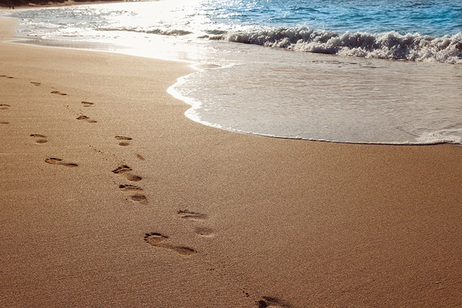 Picture of footprints in the sand by the ocean